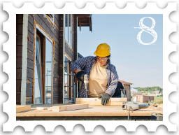 August 2022 Restoration and Rebuilding SWG challenge stamp - color photo of a construction worker using a hand tool in the foreground, with a house undergoing renovation in the background