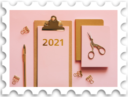 January 2023 Jubilee SWG challenge stamp - postage stamp with a color photo of a pink desktop with a writing implement, scissors, and a clipboard with the number 2021 in gold numerals