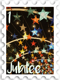 January 2025 Jubilee SWG challenge stamp - a photo of a 'tunnel' formed by hanging paper star lamps in many bright colors; the sky beyond is dark
