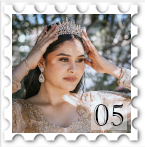 May 2025 Period Drama challenge stamp - photo of a woman placing or adjusting a tiara on her head. The background is sunlit, suggesting an outdoors scene.