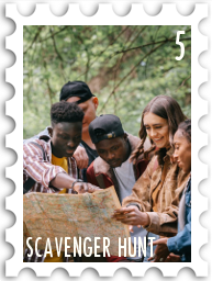 May 2026 Famous Scavenger Hunt SWG challenge  stamp - a color photo of a group of young adults clustered around a map. The coloration of the map suggests is it old, while the facial expressions of all the people are curious, intrigued, and enthusiastic. They appear to be having fun on a spring or summer day.