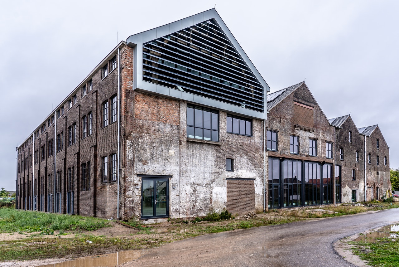 A row of four old brick warehouses with some newer looking windows.
