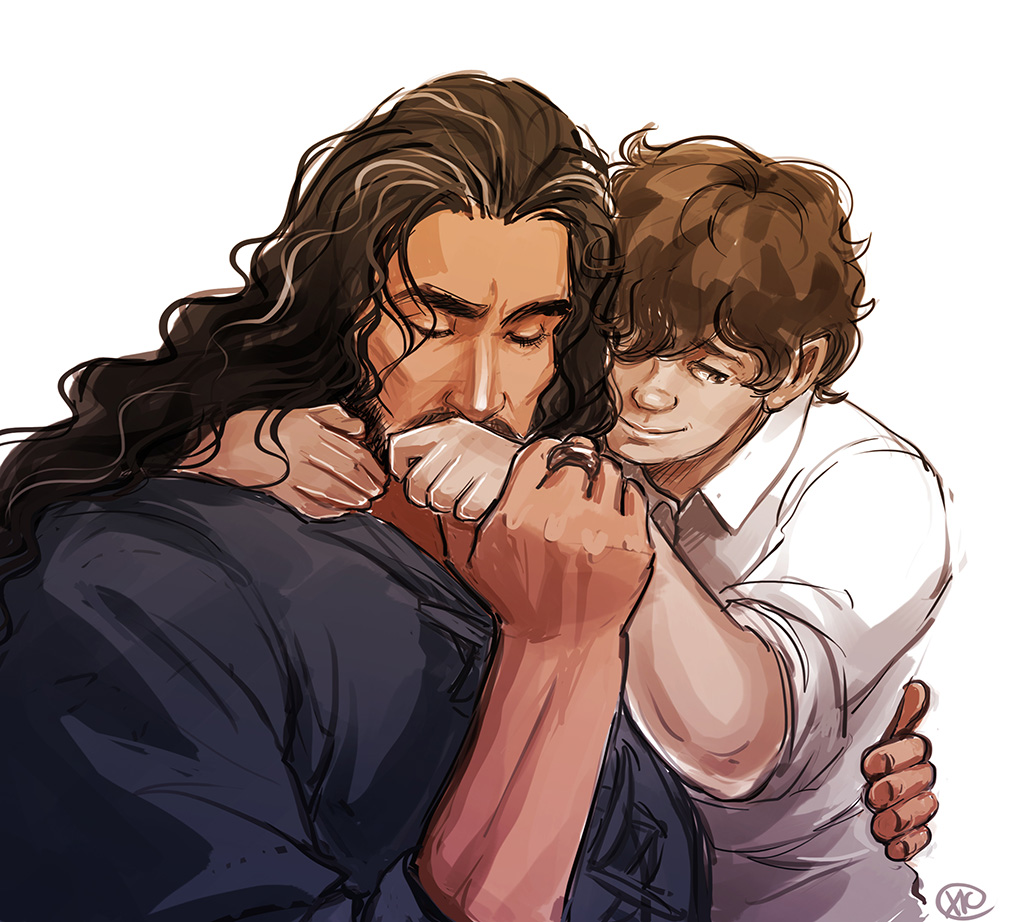 Bilbo and Thorin embrace as Thorin kisses Bilbo's hand