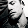 black and white photo of Sam Worthington leaning against his raised arm
