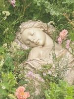 statue of a girl sleeping in a garden, overgrown with flowers
