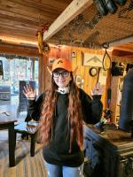 Picture of me with elven ears and an orange hat in a cabin.