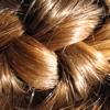 A close-up shot of auburn hair in a French braid. 